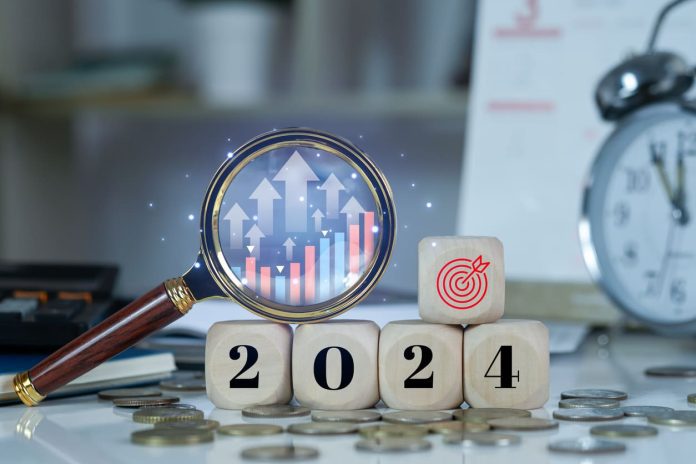 Budget 2024 with blurred office background. Wooden cubes with 2024 and goal icon on coins stack. Countdown to 2024. New year start concept. stock photo iStock-1693586140