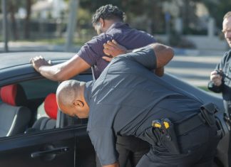 A man being searched by police officers