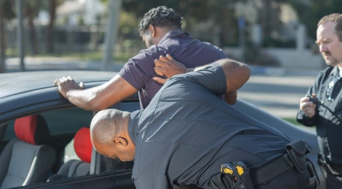 A man being searched by police officers