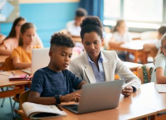 student and teacher using laptop
