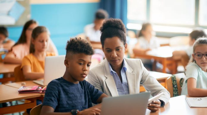 student and teacher using laptop