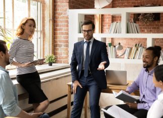 Diverse employees listen to leader