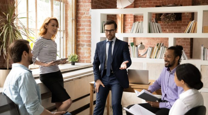 Diverse employees listen to leader