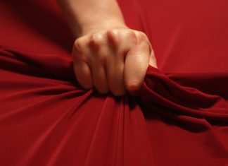 woman hand squeezes the red sheet
