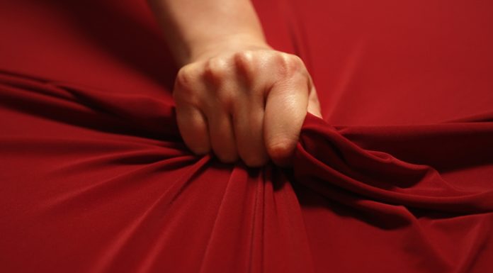 woman hand squeezes the red sheet