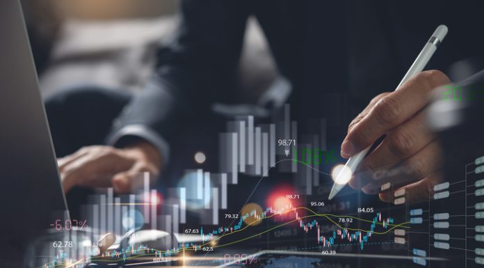 Businessman using digital tablet analyzing sales data and monitoring economic growth graph chart on virtual screen