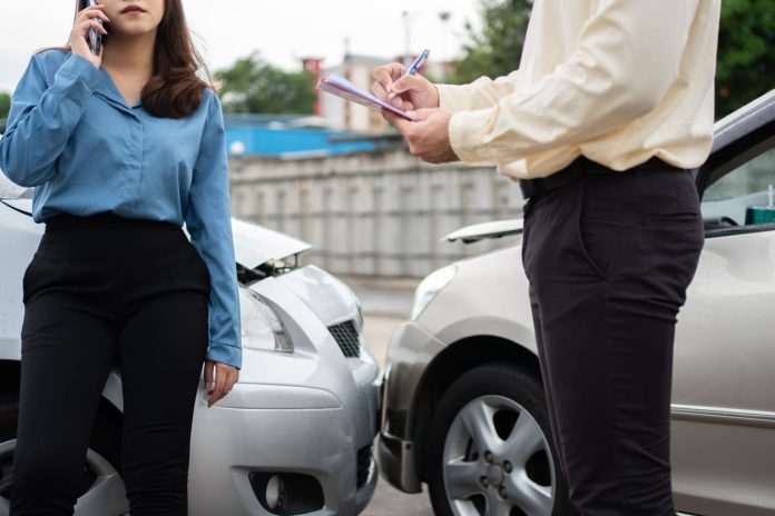Asian women driver Talk to Insurance Agent for examining damaged car and customer checking on report claim form after an accident. Concept of insurance and car traffic accidents Hire a Lawyer After Being in a Car Crash