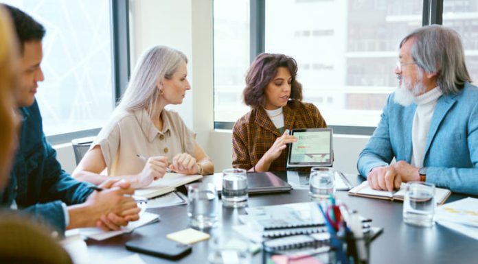 Tablet, meeting and business people in discussion in office planning creative project in collaboration.
