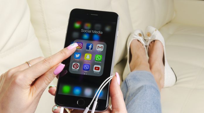 Apple iPhone 7 in woman hand with icons of social media facebook, instagram, twitter, snapchat application on screen