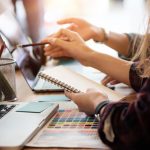 Launching Legally Sound Startups Using a Professional Company Creative team two woman working with computer in modern office, selective hands hold notebook paper.