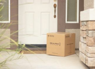 brown cardboard box beside white wooden door