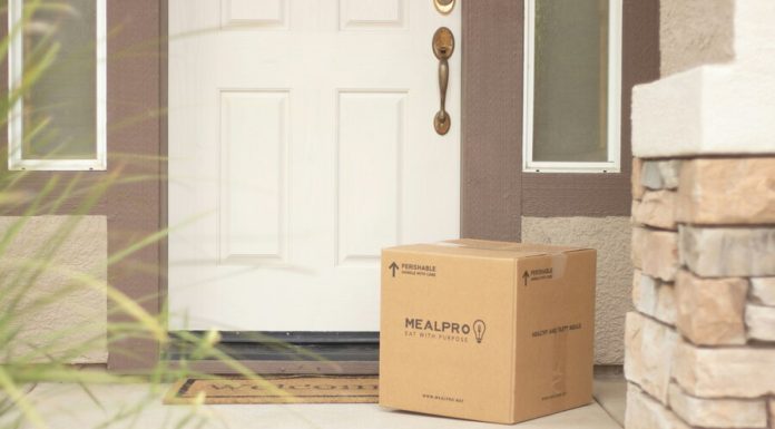 brown cardboard box beside white wooden door