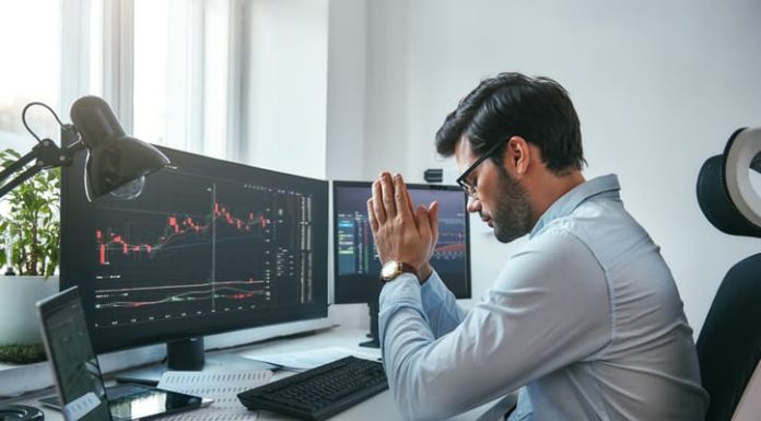 businessman holding palms together with data on monitors