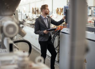 Business man checking quality on laptop in factory