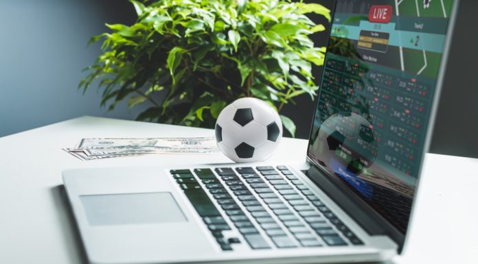 Corporate Governance and Personnel Policy in Leading Gambling Companies Close up cropped shot of white office desk with dollar banknotes and laptop with bookmaker's website interface on its screen