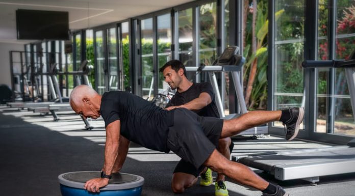 Overcoming Fitness Plateaus: Tips and Tricks from Personal Trainers Personal trainer helping an old man in the gym
