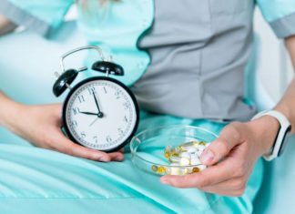 Therapist holding a alarm clock and vitamins