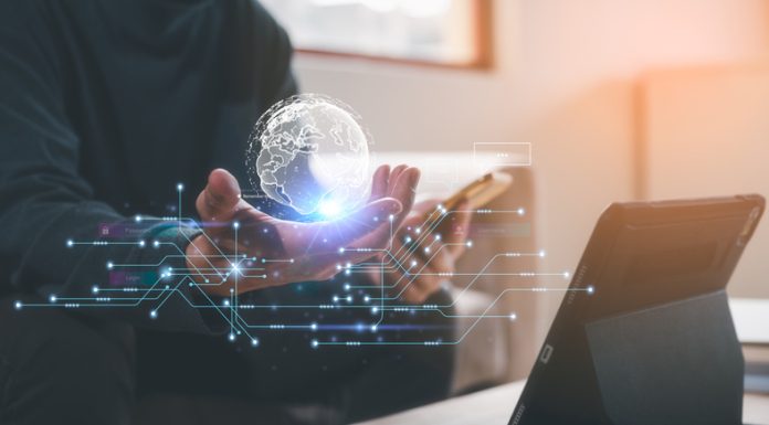 A New Dawn: 2024 Will be the Year the Frontline Comes Online Technology Concept. A man holding virtual globe icon and mobile phone