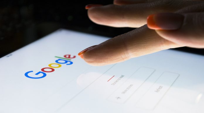 A woman's hand is touching screen on tablet computer iPad Pro at night for searching on Google search engine. Google is the most popular Internet search engine in the world.