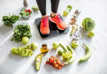 woman weighing on the scales with healthy foods around