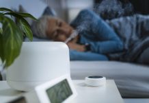 Woman sleeping in bed with air humidifier