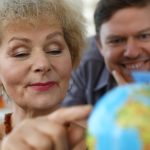 old woman exploring globe