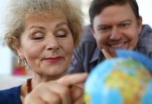 old woman exploring globe