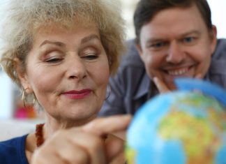 old woman exploring globe
