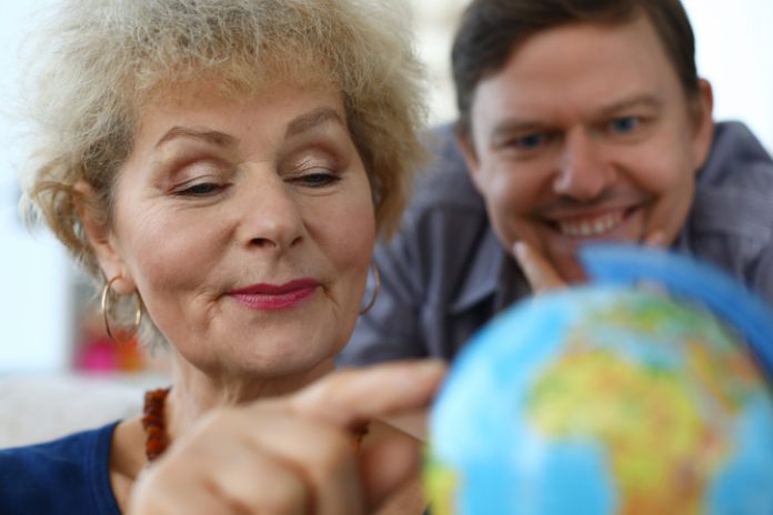 old woman exploring globe