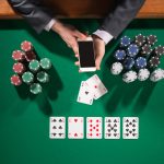 Man playing poker while holding smart phone
