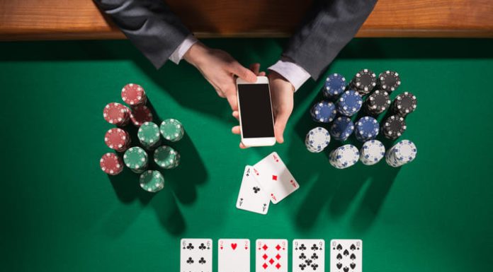 What to Look for in Casino Sites in Bangladesh Man playing poker while holding smart phone