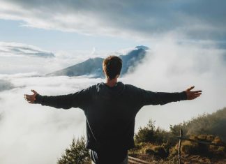Impact of High-Altitude Platforms on Communication Man with arms outstretched admiring view from mountain cliff