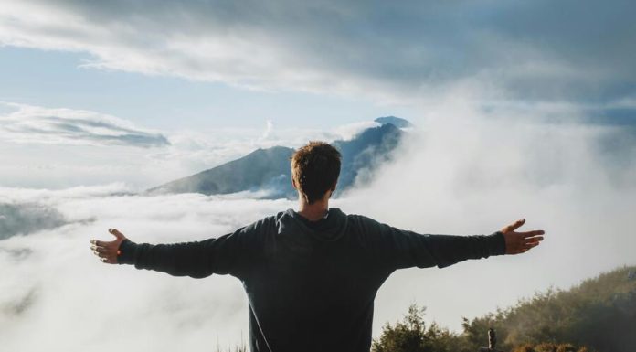 Impact of High-Altitude Platforms on Communication Man with arms outstretched admiring view from mountain cliff