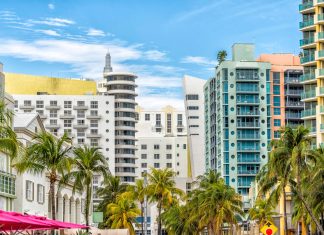 Miami South Beach Ocean Drive road street with famous retro art deco hotel colorful buildings cityscape with palm trees and blue sky on sunny day