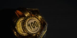 Bunch of coins in plastic cup isolated on a white background