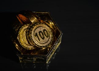 Bunch of coins in plastic cup isolated on a white background