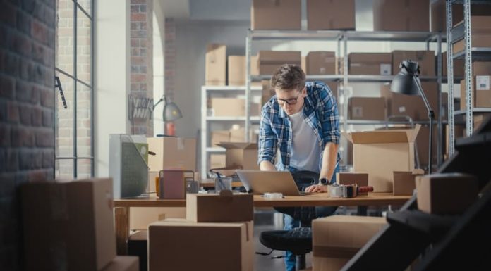 How to Choose the Right Wholesale Ecommerce Model for Your Business A man preparing a Parcel for Postage