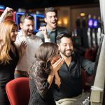 Group of people looking excited about hitting the jackpot in a slot machine