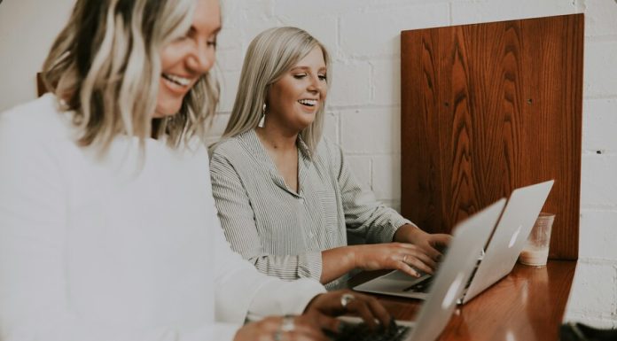 two women using laptops