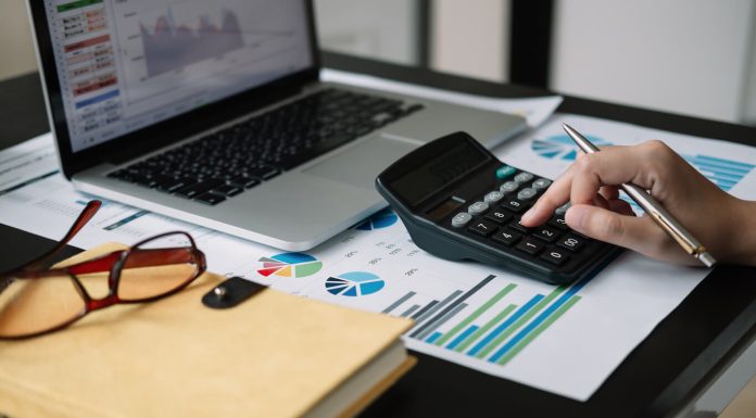 Why Modern Payroll Software is a Game-Changer for Accounting Firms Business woman calculator and laptop for calculating finance, tax, accounting, statistics and analytic research concept