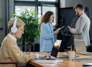 Widening the Net on Workplace Well-being: How to Safeguard Employees Against Disruptive Office Noise Woman wearing headset while working