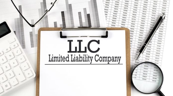 Evaluating the Benefits: Is Forming an LLC The Right Move for Your Business? LLC with calculator and magnifying glass