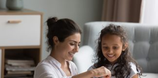 mother and kid dropping cash into piggy bank