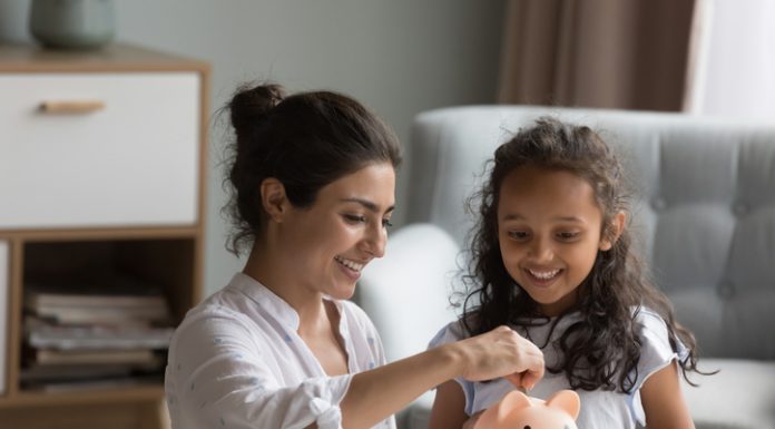 Teaching Your Kids the Value of Saving: Opening Their First Savings Account mother and kid dropping cash into piggy bank