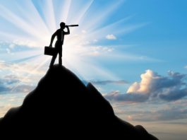 Silhouette of a businessman looking through a telescope