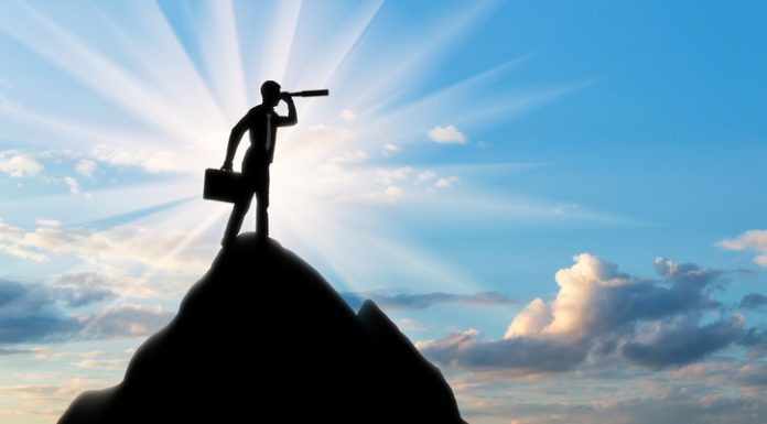 Silhouette of a businessman looking through a telescope