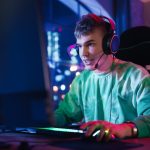 Compliance and Responsible Gaming in the iGaming Industry Gaming at Home: Portrait of a Gamer Wearing Headphones and Playing Online Game on Personal Compute