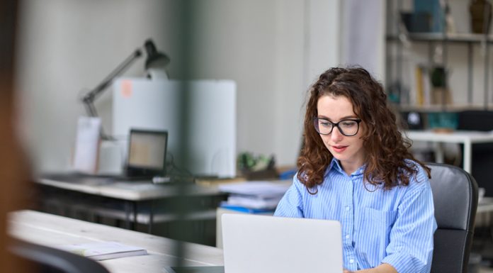 Top Benefits of Using a Virtual Office for Your Business Woman employee sitting at desk working online on laptop