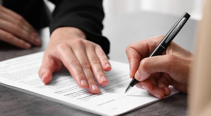 Sign Documents Online With Quicksigner.com: The Quick and Affordable Electronic Signature App for Successful Agreements. Manager showing client where she must to mark signature at dark table, closeup