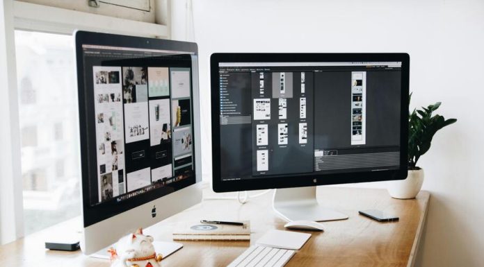 Two Imac's With Keyboard and Phones on Desk